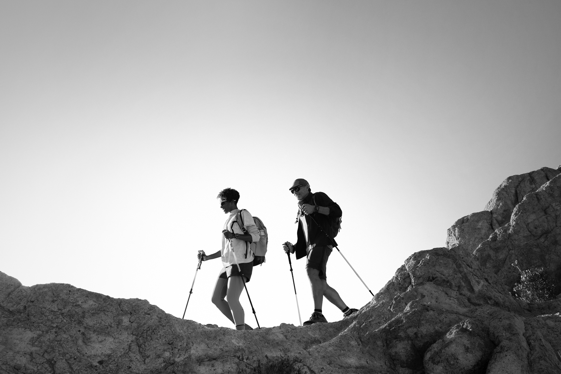 Dos personas con un Apple Watch Ultra 3 hacen senderismo en la montaña