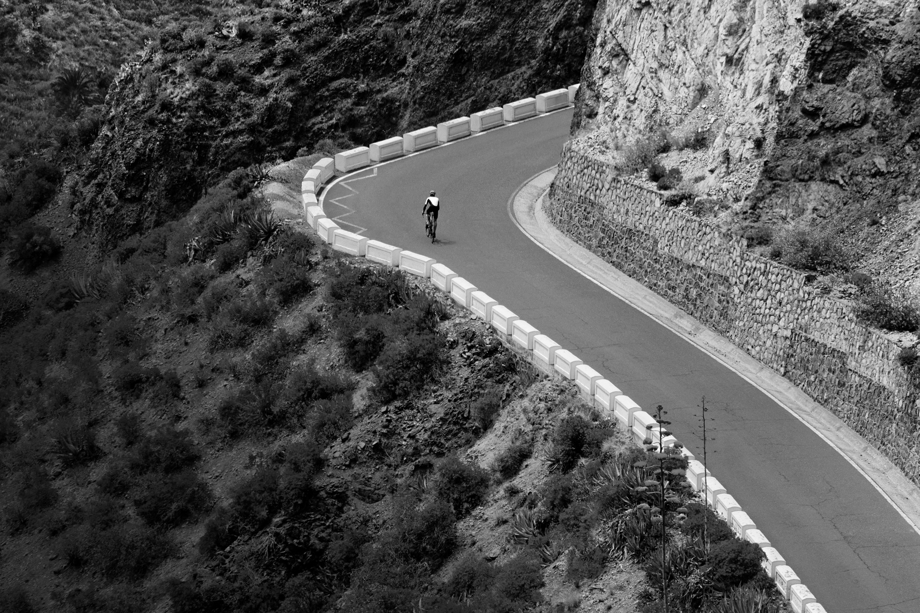 Ciclista a subir uma estrada de montanha